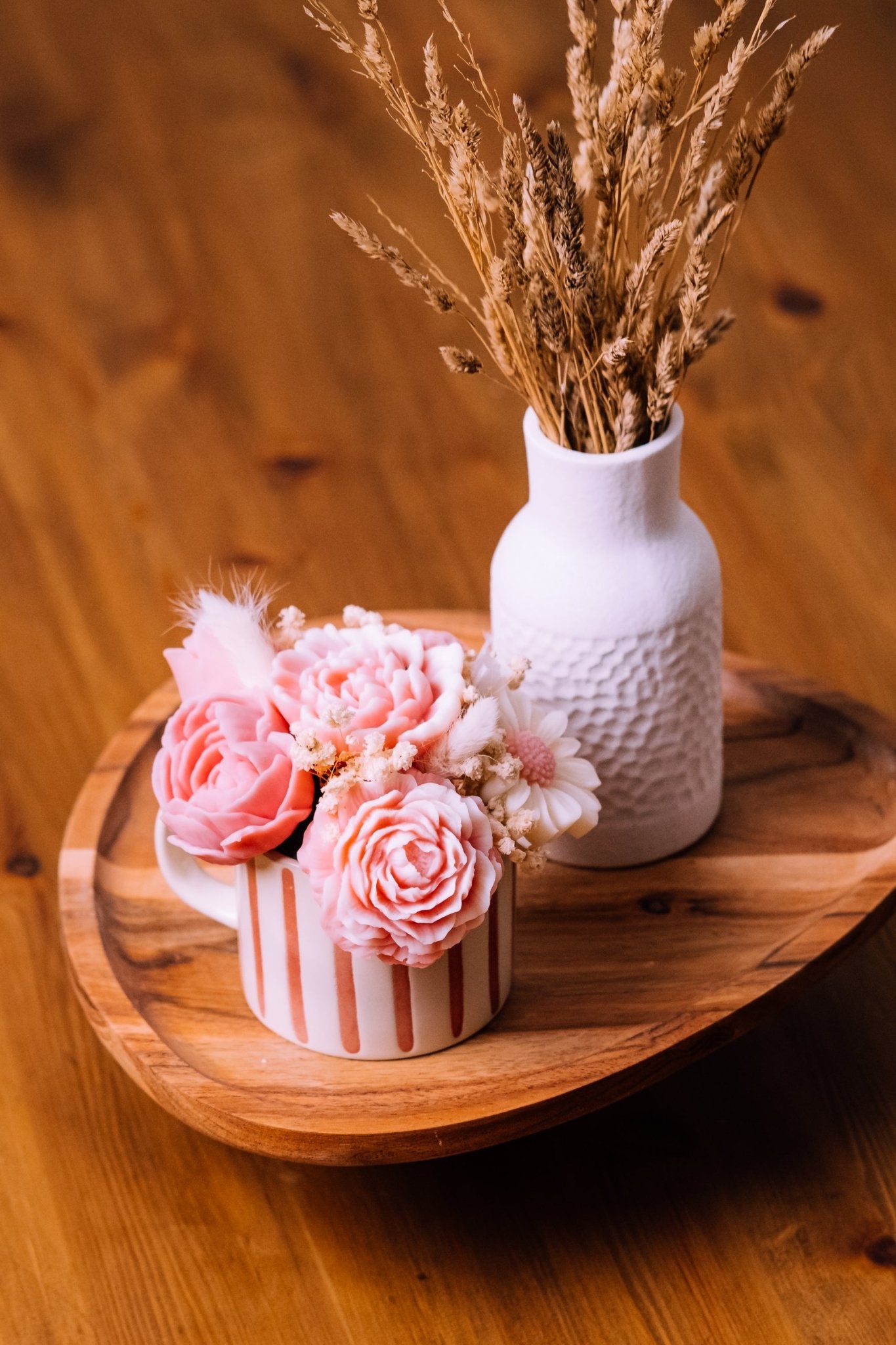 herzton Blumentasse mit Wachsrosen und Trockenblumen in rosa-weiß gestreifter Tasse auf Holztablett