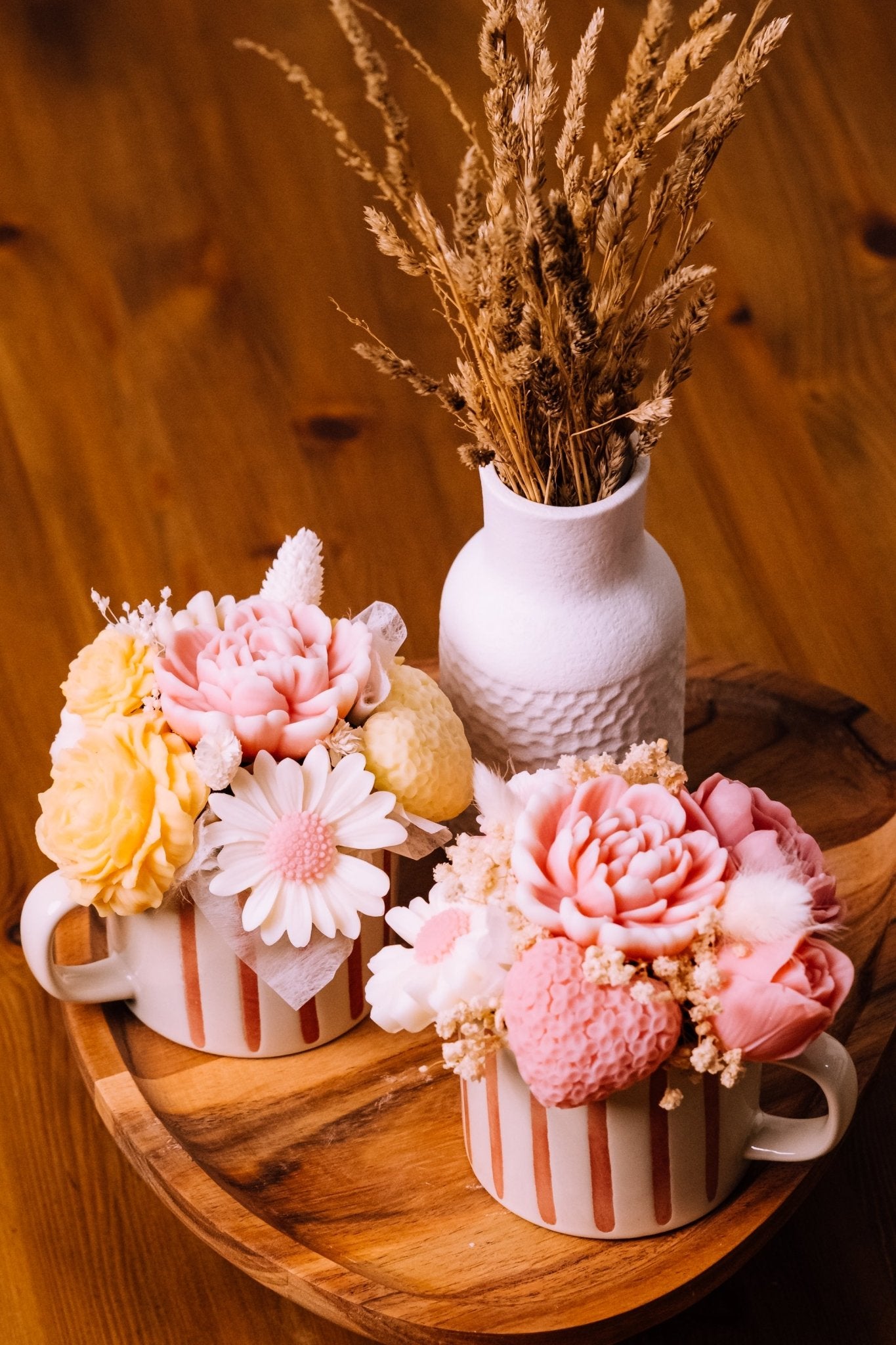 herzton Blumentasse von oben, dichtes Bouquet aus Wachsblumen und Trockenblumen in gestreifter Keramiktasse