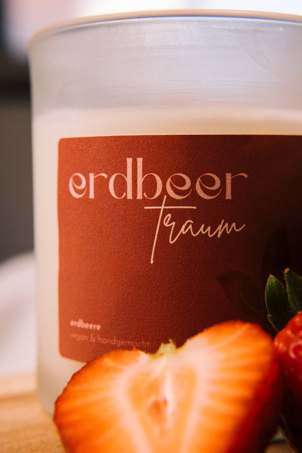 herzton Erdbeer Traum seitlich, frische Erdbeere halb aufgeschnitten daneben, weiße Vase im Hintergrund