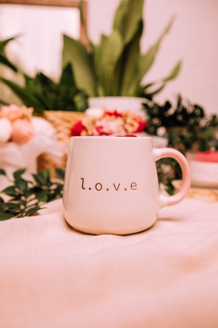 herzton Flame of Love vegane Kerze in Tasse, umgeben von Blumen und Grünpflanzen