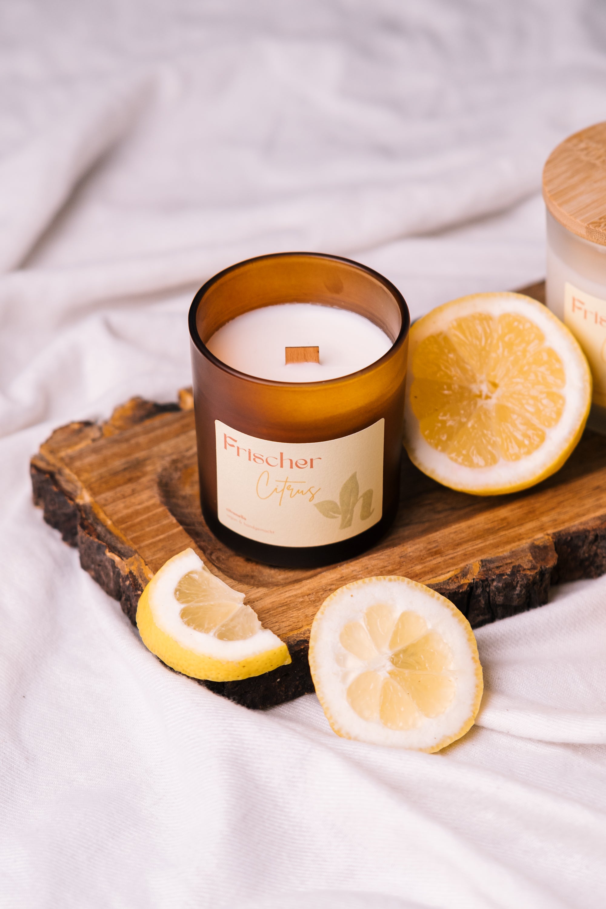 herzton Frischer Citrus Kerze brennend auf Sommerabend-Arrangement
