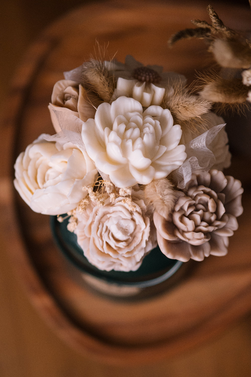 Handgefertigte Wachsblüten in Creme und Taupe in einer Glasvase, mit Trockenblumen und Pampasgrasstängeln