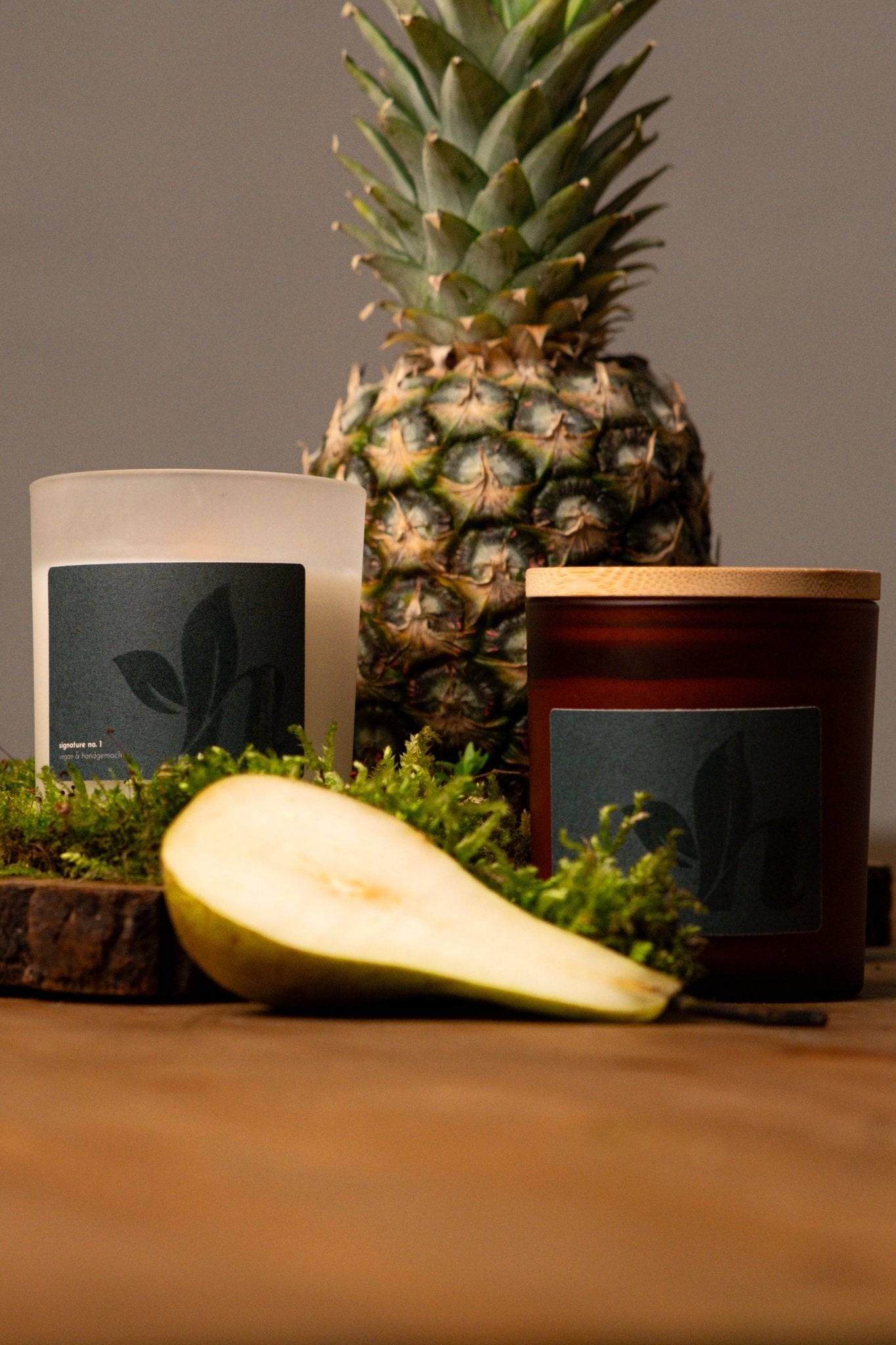 herzton Signature Kerze im Milchglas und Bernsteinglas nebeneinander, Ananas und Birne als Duft-Dekoration