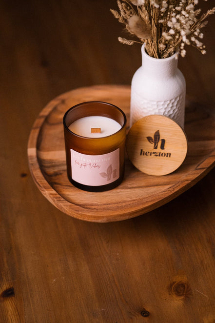 herzton Gute-Vibes-Kerze auf Holztablett, Bambusdeckel und weitere herzton Kerze im Hintergrund