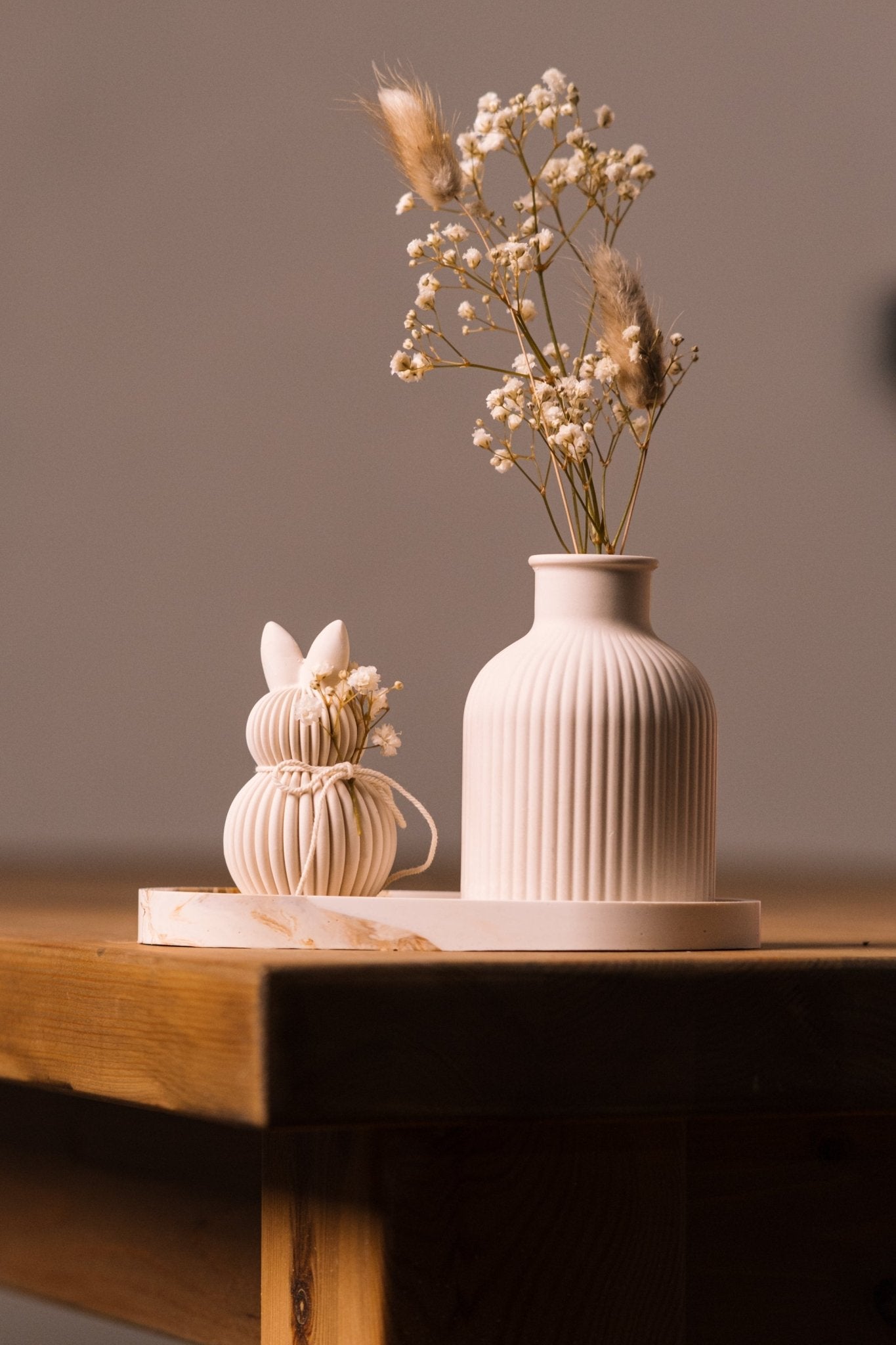 herzton Oster Deko Set Detailansicht Hasenfigur mit Kordel neben Rillenvase mit Schleierkraut