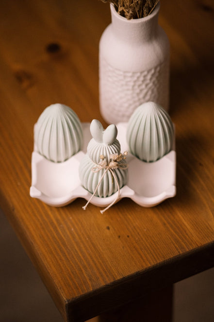 herzton Oster-Moment Arrangement, weißes Raysin-Nest mit Ostereiern und Hasenfigur auf Holz