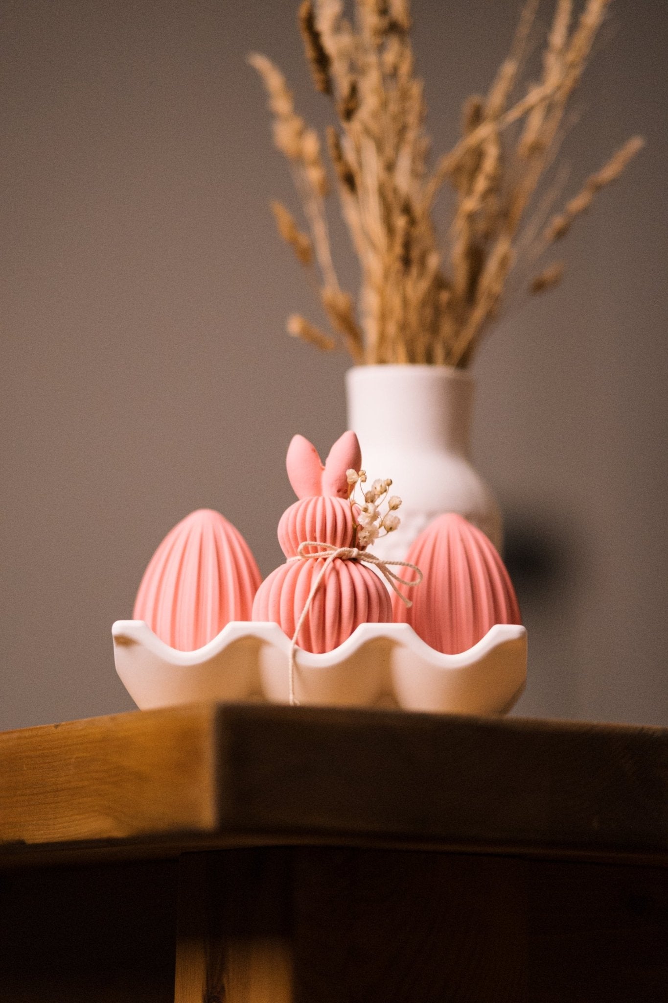 herzton Oster-Moment Detailaufnahme Hase mit geflochtenem Kordelmuster und Blütendeko
