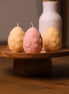 herzton Osterei Standkerzen in Rosa, Gelb und Apricot mit Margariten-Relief auf Holzsockel