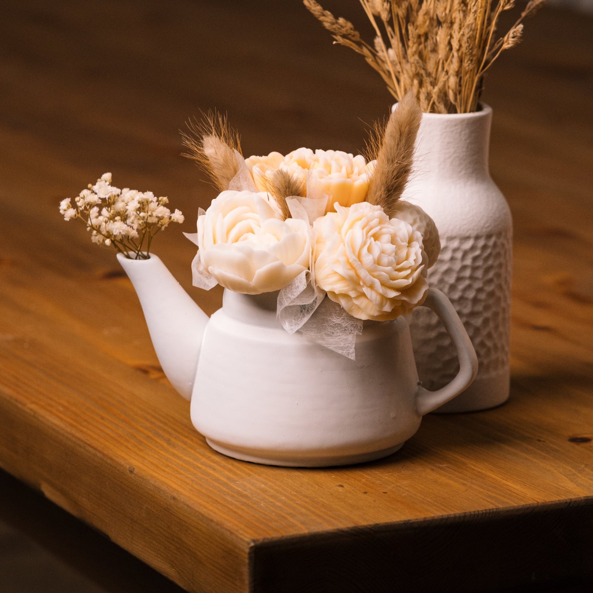 herzton Porzellan-Kanne weiß mit Wachsblumen-Strauß aus Rosen und Trockenblumen auf Holztisch