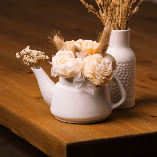 herzton Porzellan-Kanne weiß mit Wachsblumen-Strauß aus Rosen und Trockenblumen auf Holztisch