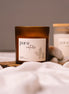 herzton Pure Nature Sojawachskerze im Bernsteinglas mit weißem Etikett "pure nature – ohne duft", auf Holz mit Steinen