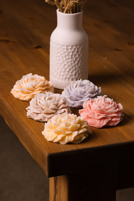 herzton Rose Standkerzen in Pastellfarben Apricot, Beige, Lila, Rosa und Gelb auf Holztisch
