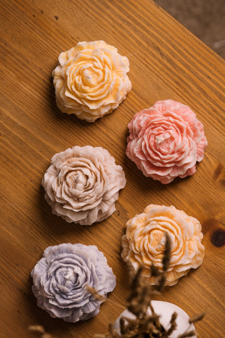 herzton Rose Standkerzen von oben, fünf verschiedene Pastellfarben auf Holztisch mit Trockenblume