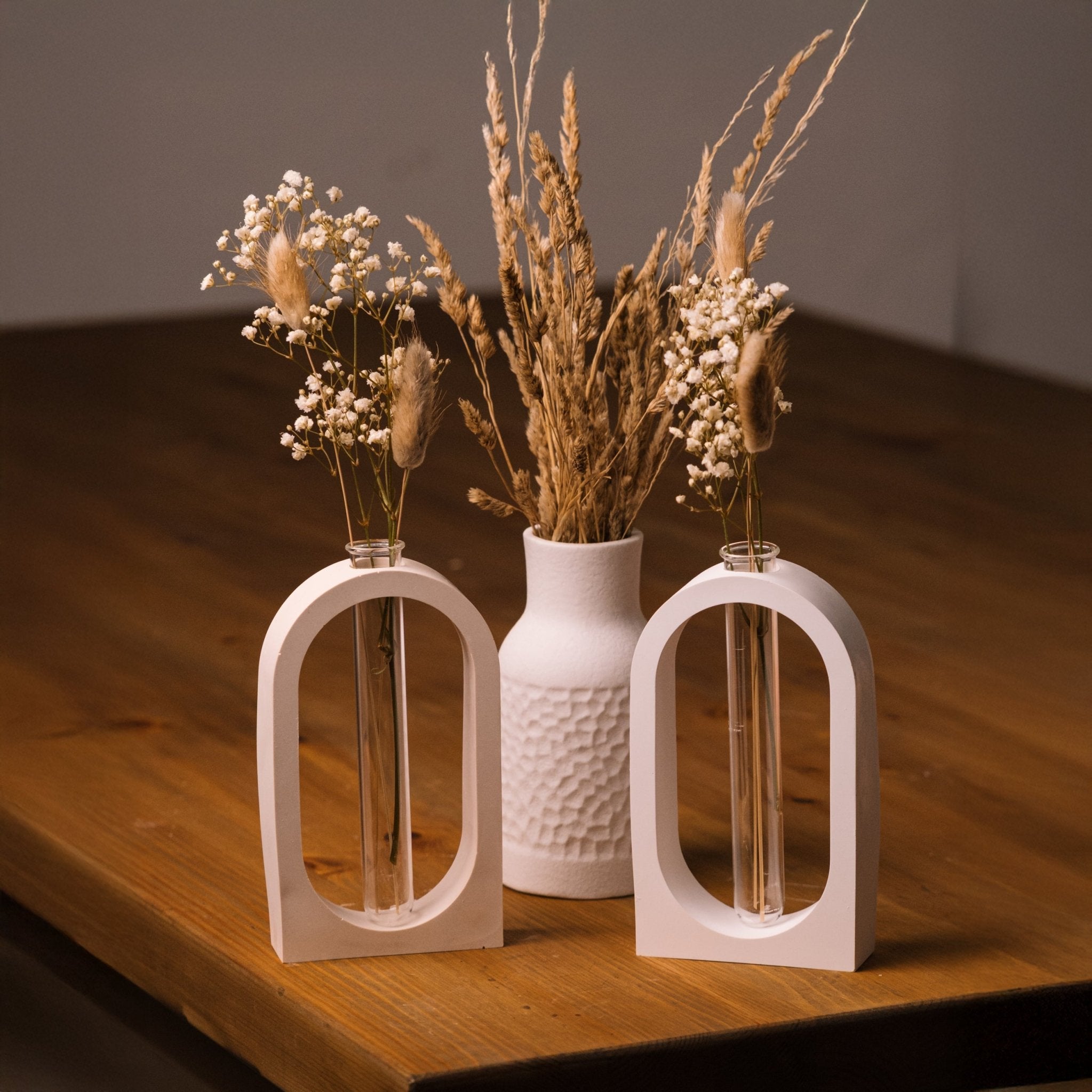 herzton Vasen-Halter zwei weiße Raysin-Bögen mit Glasröhrchen und Trockenblumen auf Holztisch